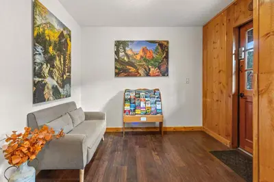 a living room with a couch and paintings on the wall at Cabin16 - King Bed Kitchenette & Bath in Estes Park