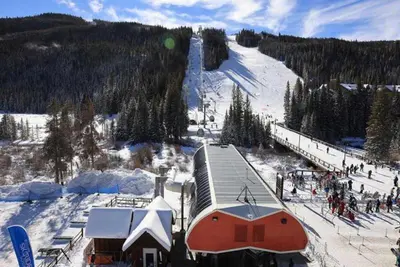 a snow covered ski slope with a building and a ski lift at Kindred Resort Luxury Ski In, Ski Out 3 Bedroom Residence At The River Run Gondola in Dillon