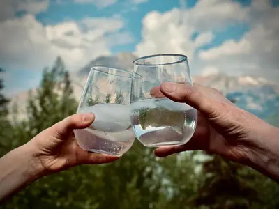 two people holding glasses of water in their hands at Winter Park Condo with Fireplace and Mountain Views in Winter Park