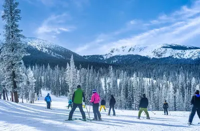 a group of people skiing down a snow covered slope at Winter Park Condo with Fireplace and Mountain Views in Winter Park