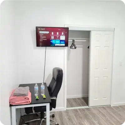 a room with a desk and a television on a wall at Sweet stay near Denver airport in DEN