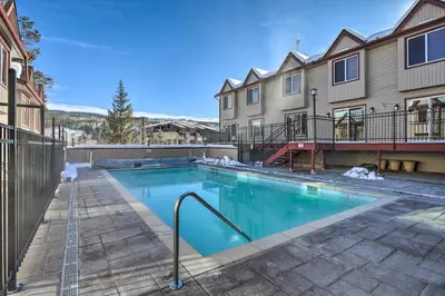 a swimming pool in front of a building at Shuttle to Winter Park Resort! Group Condo with Pool in Winter Park