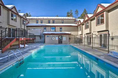 a swimming pool in the courtyard of a apartment building at Ski, Soak and Chill! Pool-View Winter Park Condo in Winter Park