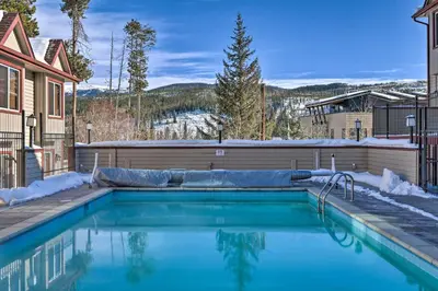 a swimming pool in front of a house at Ski, Soak and Chill! Pool-View Winter Park Condo in Winter Park