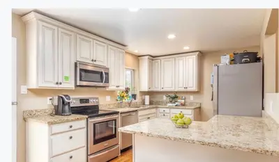 a kitchen with white cabinets and a stainless steel refrigerator at Master Bedroom and Bath in Arvada