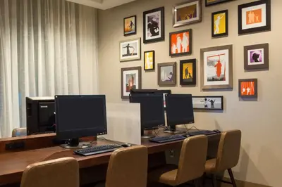 a desk with three computer monitors on top of it at Hyatt House Denver Downtown in Denver