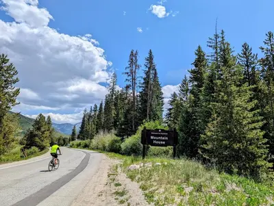 a person riding a bike down a road with a sign at Chateaux DuMont 2710 by SummitCove Lodging in Keystone
