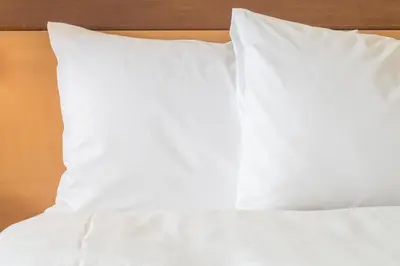 a bed with white sheets and pillows on it at Candlewood Suites Denver North - Thornton by IHG in Thornton