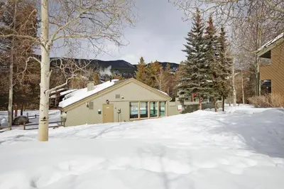 a snow covered yard with a house in the background at 1125 Flying Dutchman Condo in Keystone