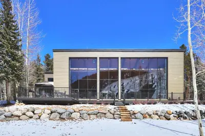 a house with large glass windows in the snow at 2130 Pines Condo in Keystone