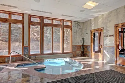 a hot tub in a room with windows at 3056 The Timbers Condo in Keystone