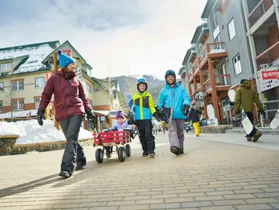 three people walking down a street with a child in a wagon at Expedition Station 8566 in Keystone