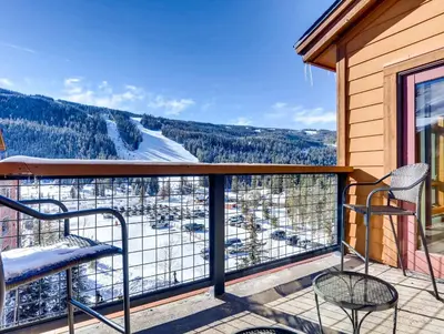 a balcony with two chairs and a view at Red Hawk 2272 in Keystone