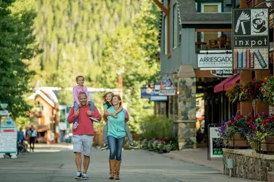 a man and woman walking down a street with a child on their backs at Slopeside 2741 in Keystone