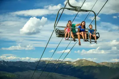 a group of people sitting on a ski lift at Silver Mill 8308 in Keystone