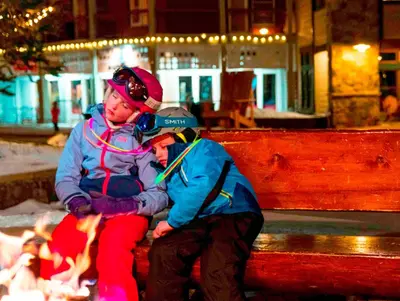 two people sitting on a bench next to a fire at Expedition Station 8613 in Keystone