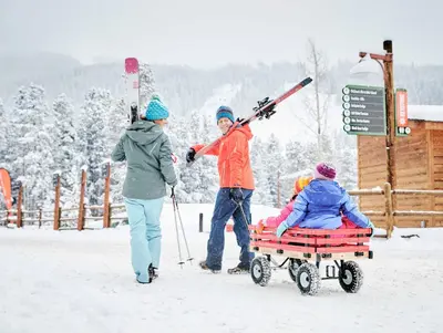 a group of people pulling a person in a sled in the snow at Buffalo Lodge 8325 in Keystone