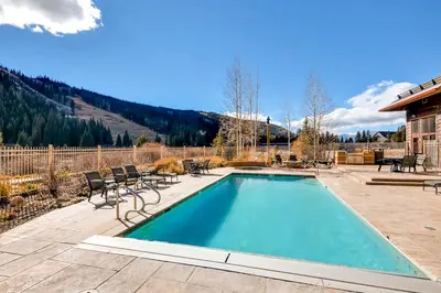 a swimming pool with chairs and a house at Red Hawk 2291 in Keystone