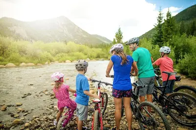 a group of people standing next to a river with bikes at Gateway 5070 in Keystone