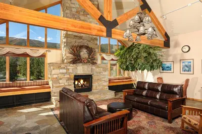 a living room with a stone fireplace and leather furniture at Gateway 5070 in Keystone