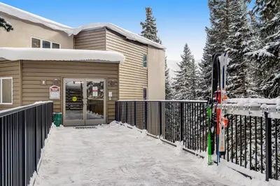 a house with a gate and skis in the snow at Iron Horse Studio in Winter Park
