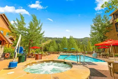 a swimming pool in a yard with umbrellas at River Run Village 1 Bedroom Condo in Keystone