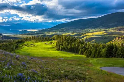 a view of a golf course with mountains in the background at Jackpine 8021 in Keystone