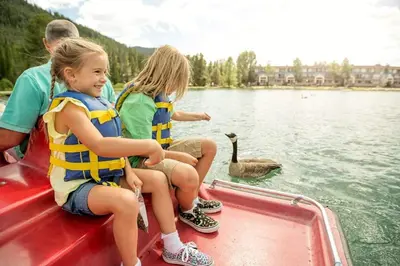 two girls and a man on a boat with a swan at Ski Tip Townhomes 8713 in Keystone