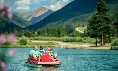 a group of people sitting on a boat in the water at River Run Townhome RR42 in Keystone