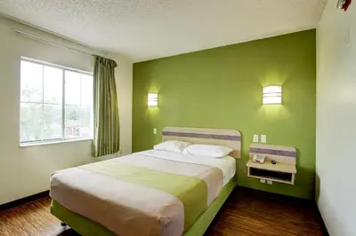 a bedroom with a bed with a green wall at Super 8 by Wyndham Aurora East in Aurora