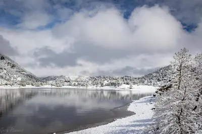 a lake covered in snow with mountains in the background at Blue Jay Bungalow in Estes Park