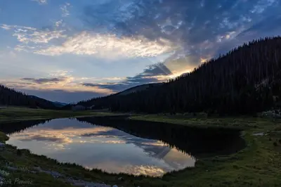 a lake in the middle of a field with trees at Bighorn Mountain 19B Condo in Estes Park