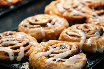 a bunch of donuts with icing on a tray at Holiday Inn Express & Suites Denver North - Thornton by IHG in Thornton