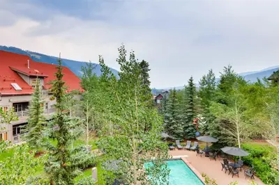 an aerial view of a resort with a pool and trees at 1 Bedroom Colorado Vacation Rental In River Run Village Steps From The River Run Gondola in Keystone