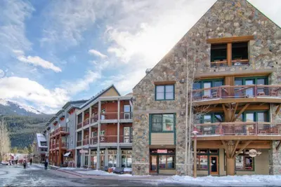 a large building with people walking in front of it at 1 Bedroom Silvermill Rental In River Run Village Steps From The River Run Gondola in Dillon