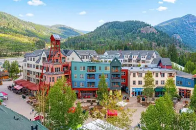 a group of buildings in a town in the mountains at 1 Bedroom Silvermill Rental In River Run Village Steps From The River Run Gondola in Dillon