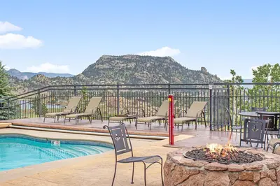 a patio with chairs and a fire pit next to a pool at Mount Acoma 38 Condo in Estes Park