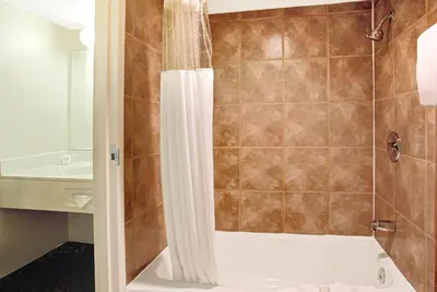 a bathroom with a shower and a toilet and a sink at Super 8 by Wyndham Wheat Ridge/Denver West in Wheat Ridge