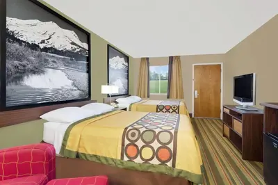 a hotel room with a bed and a television at Super 8 by Wyndham Denver Central in Denver