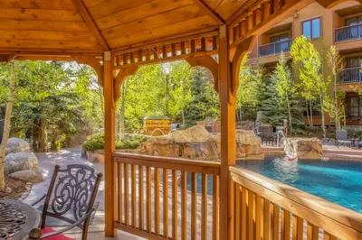 a wooden gazebo with a swimming pool at River Run Village in Keystone