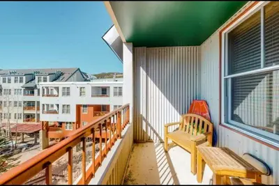 a balcony with a bench and a view of a city at 1 Bedroom Mountain Chic Condo In River Run Village Just A Short Walk To Shopping, Dining, And Skiing in Keystone