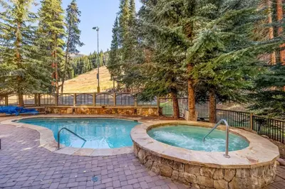 a swimming pool in a yard with trees at Premier 1 Bedroom Ski In, Ski Out Lone Eagle Condo With The Best Access To Skiing In Keystone in Keystone
