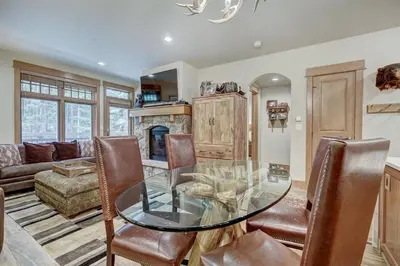 a dining room with a glass table and a fireplace at Premier 1 Bedroom Ski In, Ski Out Lone Eagle Condo With The Best Access To Skiing In Keystone in Keystone