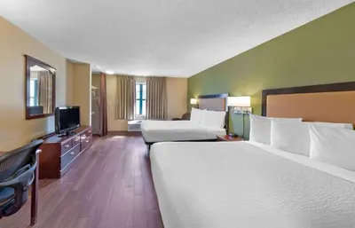 a hotel room with two beds and a flat screen tv at Extended Stay America Suites - Denver - Tech Center South - Inverness in Centennial