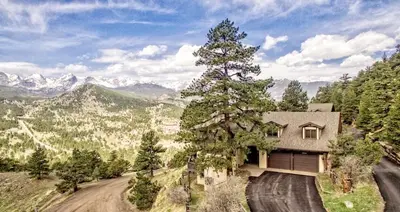 a house on a dirt road with a tree at Destiny Family Vacation Home At Windcliff Home in Estes Park