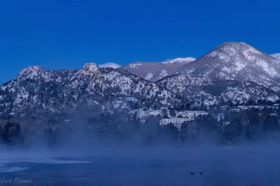 a snowy mountain range with a town in the middle of a lake at Jackstraw Mountain 32 Condo in Estes Park