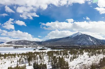 a view of a snowy mountain with trees and a lake at Ore House 8 in Frisco