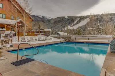 a large swimming pool in front of a ski resort at 1 Bedroom Premier Mountain Condo In River Run Village Just A Short Walk To Shopping, Dining, And Skiing in Keystone