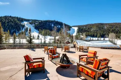 a patio with chairs and a table and a fire pit at Ski In 3 Bedroom At Chateaux Dumont Keystone in Keystone