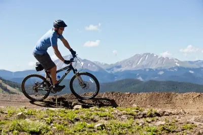 a man riding a bike on a mountain trail at Private 2 Bedroom Townhome Located In East Keystone With Access To A Firepit, Hot Tub, And Billiards in Keystone